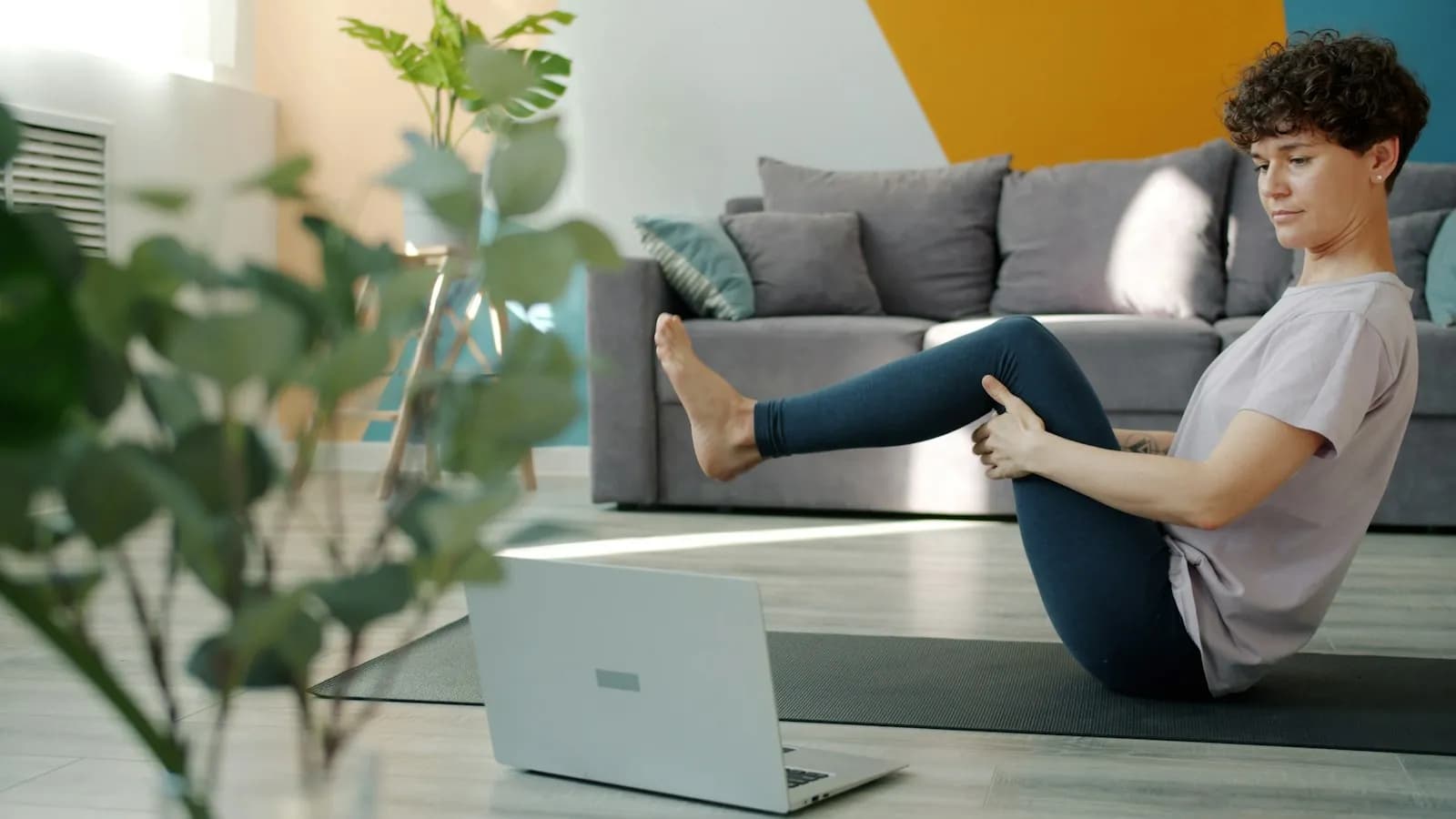 Practising yoga at home with a laptop